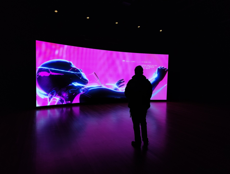 Figure standing in front of a large video display